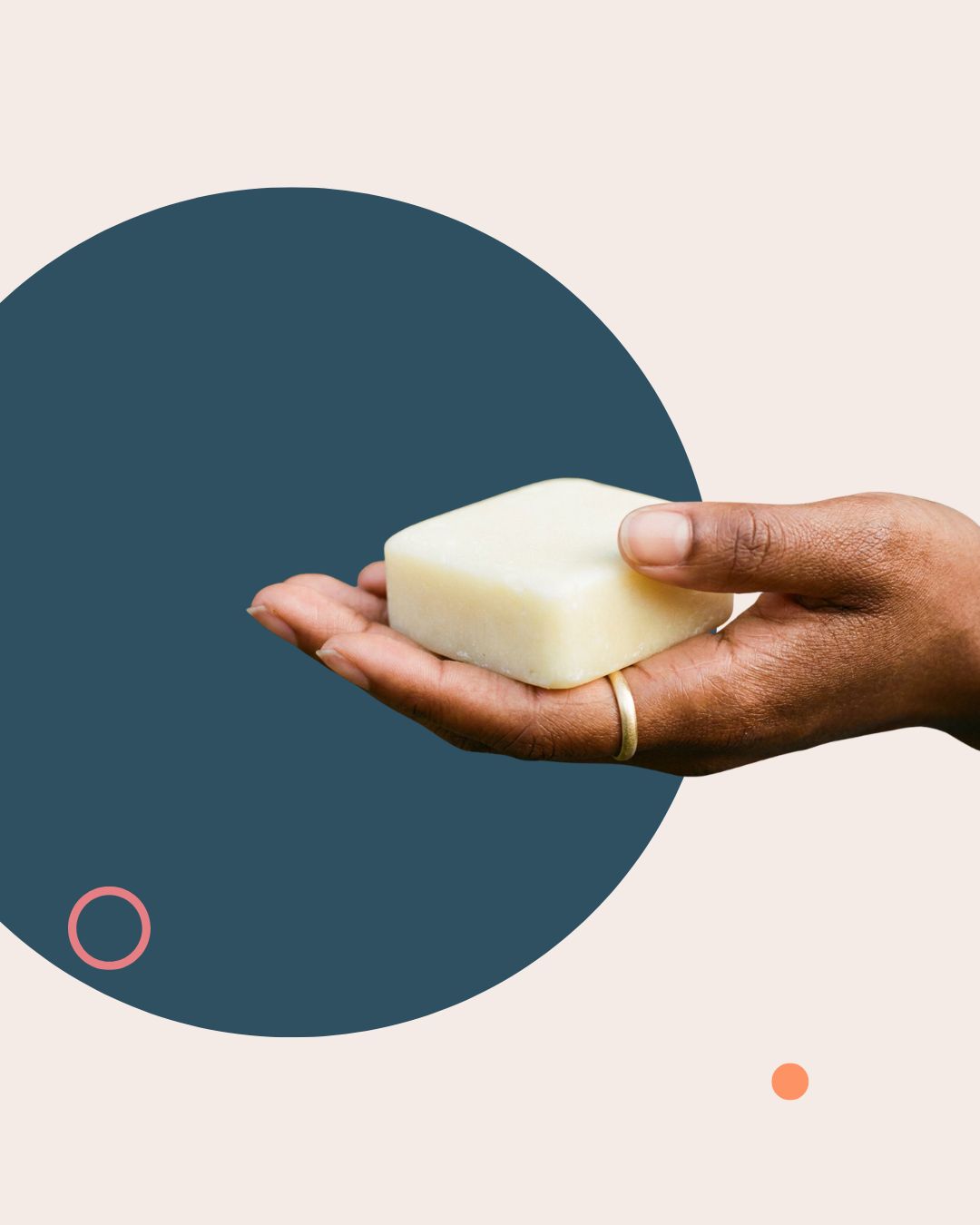 A hand holding the cocoa almond conditioning bar
